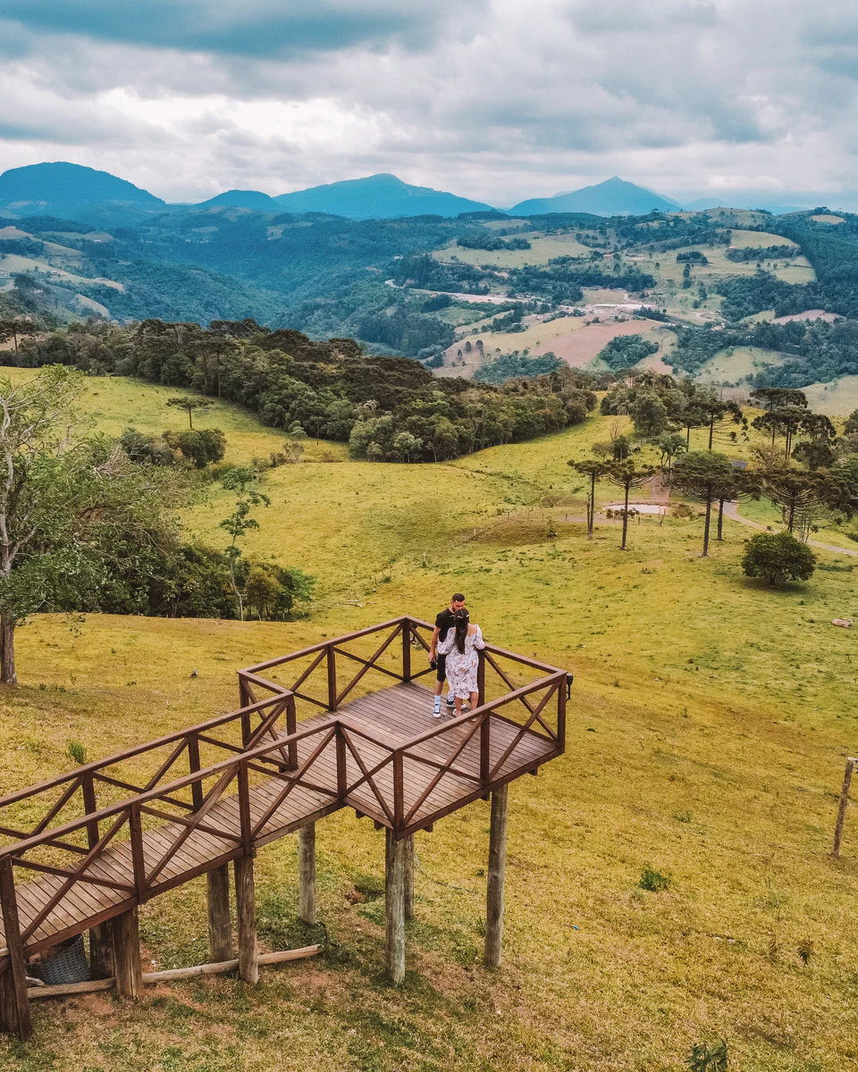 Casal no Mirante Panorâmico, com o vale e as montanhas ao fundo