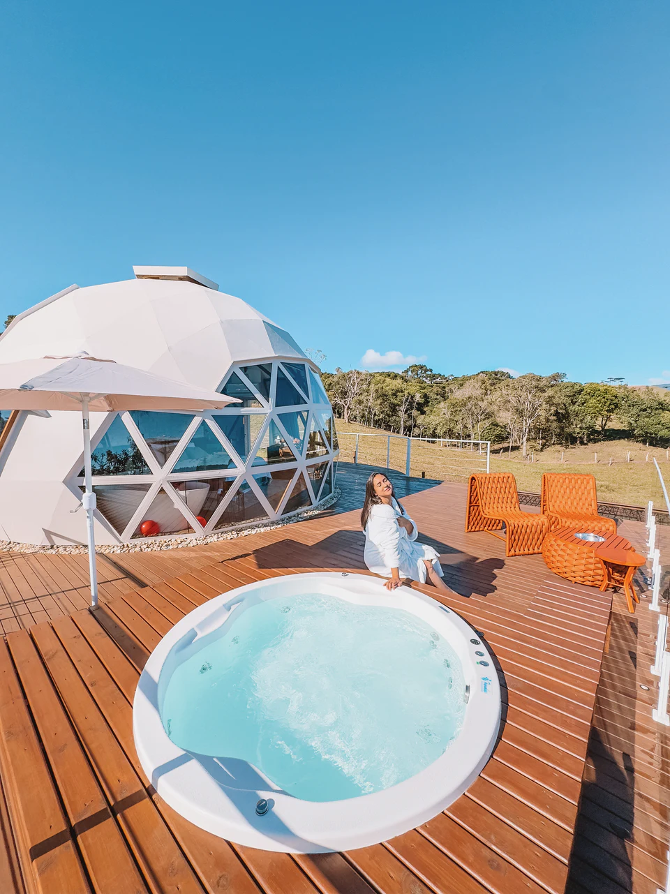 Jacuzzi externa do Domo Estelar, com o domo e o céu azul